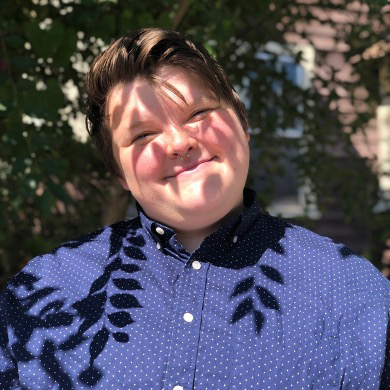 Kara Gibson smiling under a shaded tree.