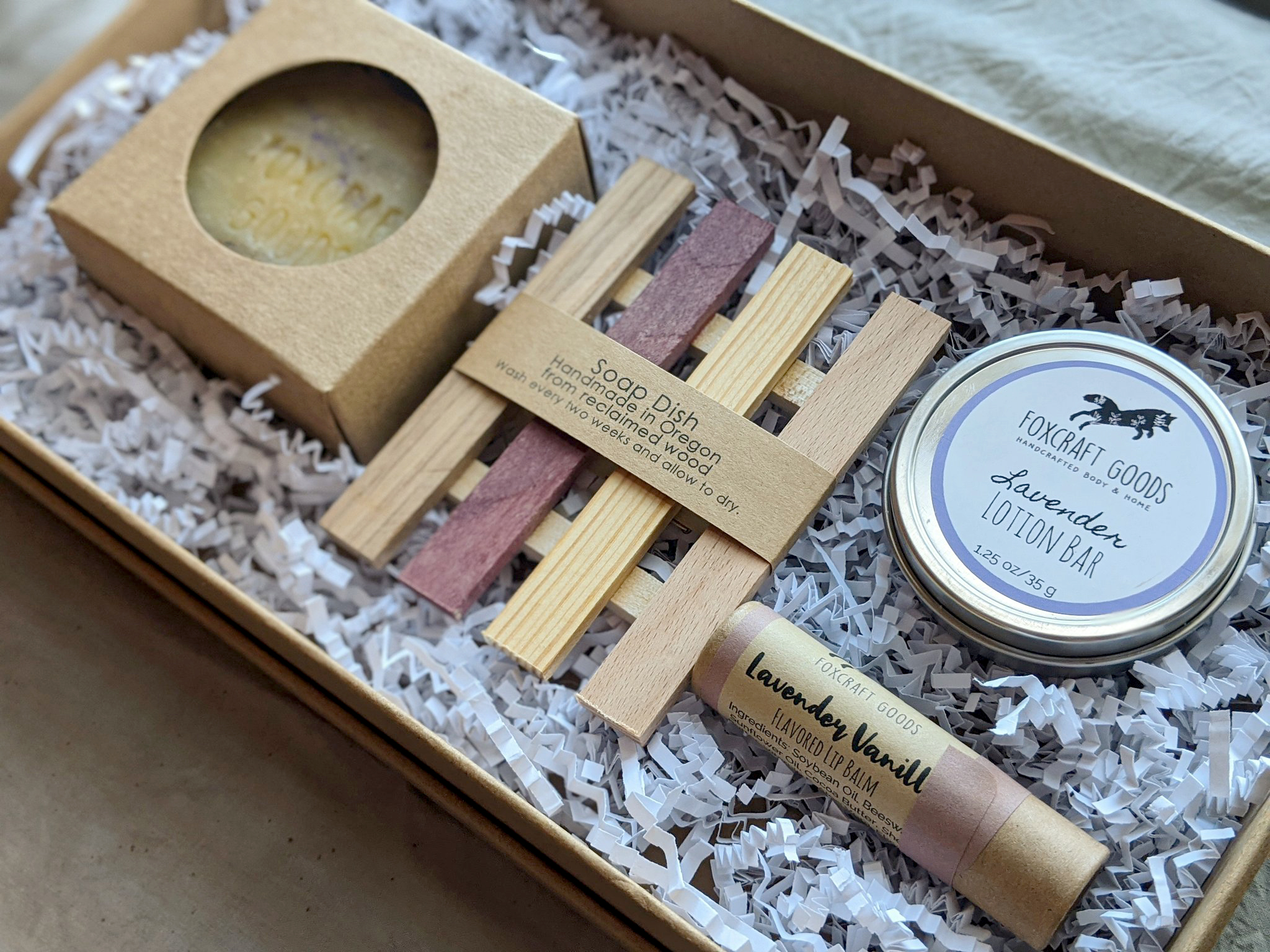 Close up of a gift box with lavender lotion, a handmade soap dish, and a bar of soap